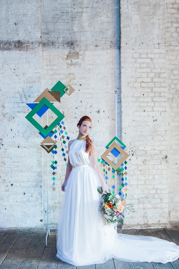 Bride standing in front of geometric wedding backdrop