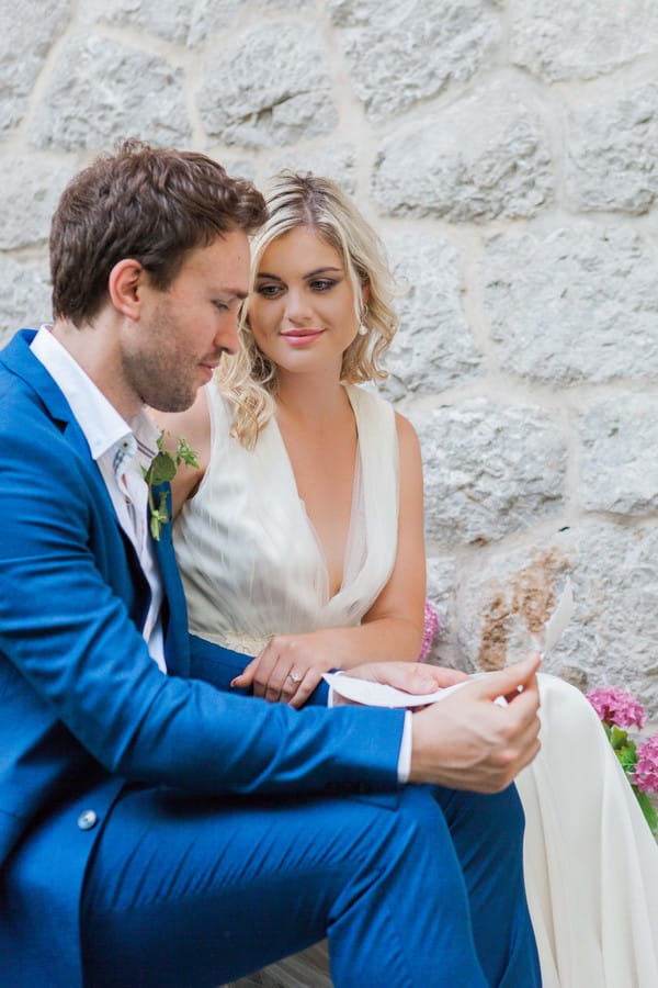 Bride listening as groom reads note