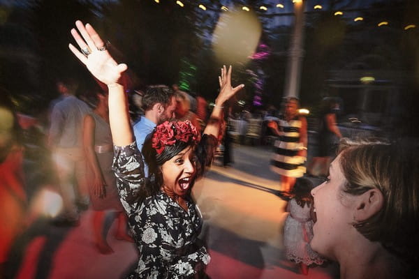 Wedding guest with arms in the air on dance floor
