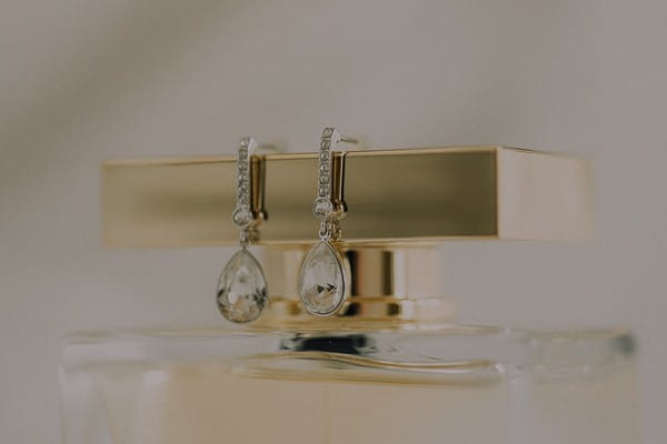 Earrings on top of perfume bottle