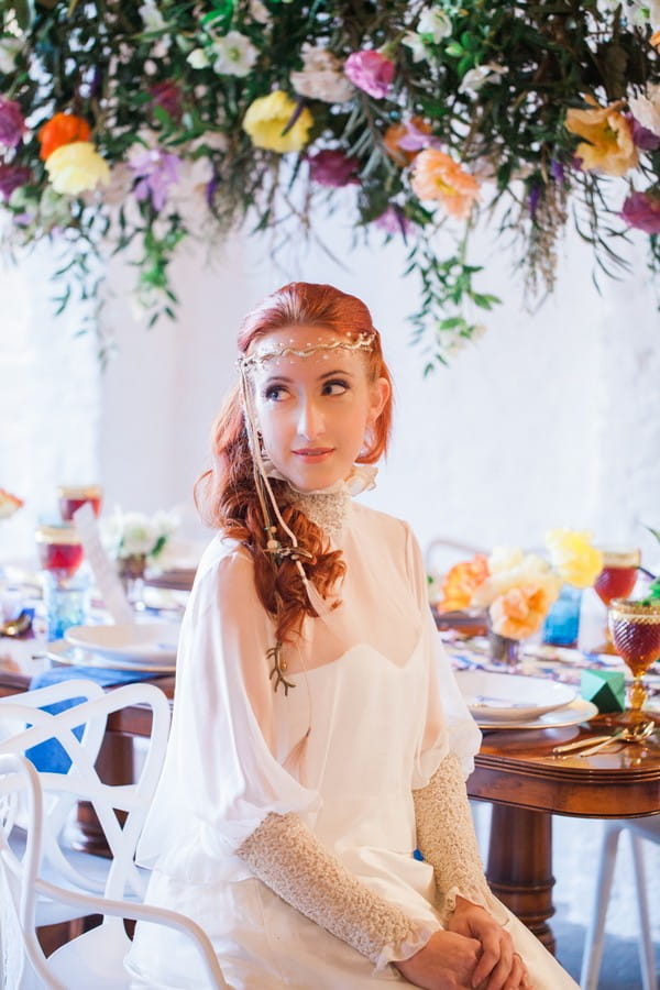 Bride wearing forehead chain sitting at wedding table