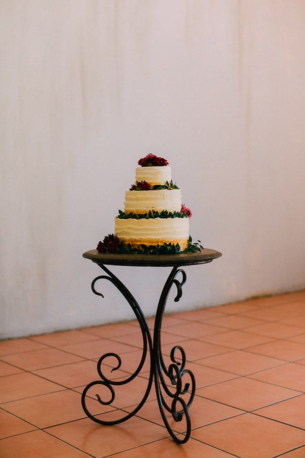 Cream wedding cake with foliage and berries