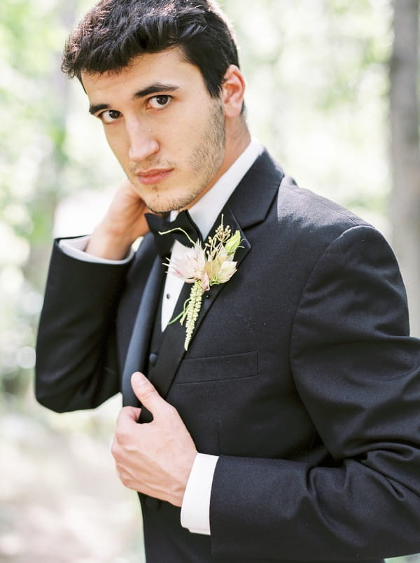 Groom wearing black suit and bow tie