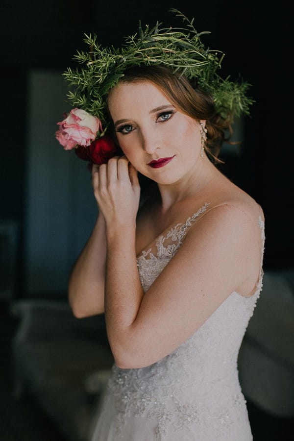 Bride with flower crown putting on earring
