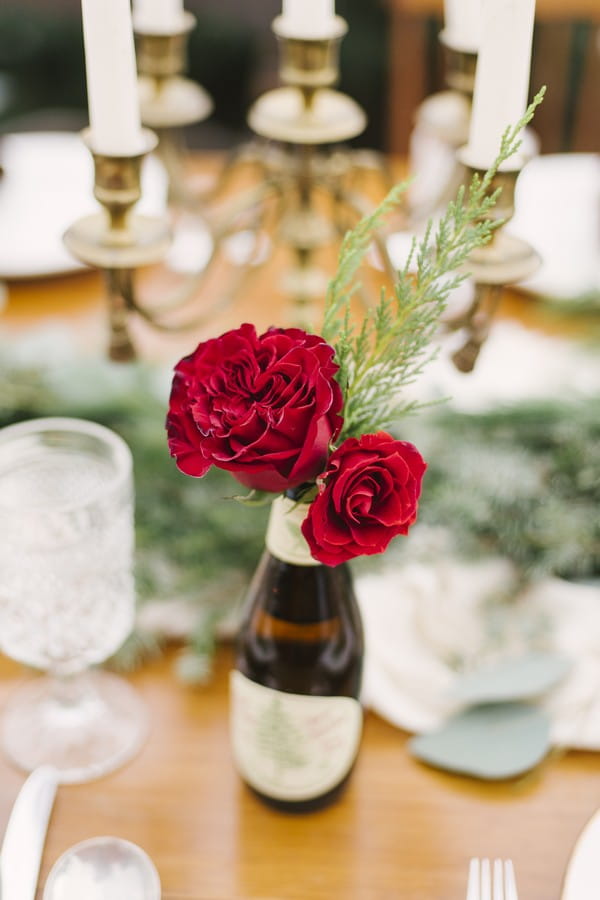 Red roses in bottle on wedding table