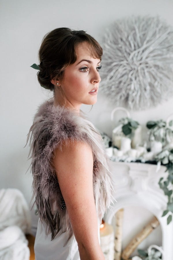 Bride with updo wearing fur and feather shrug