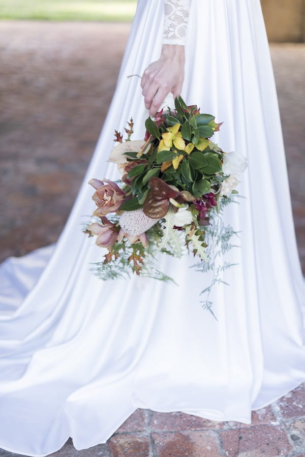 Bride holding winter wedding bouquet by her side