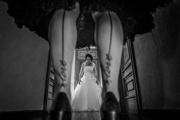 Picture of bride taken through legs of woman wearing tights with love written on seam - Picture by Alberto De La Fuente