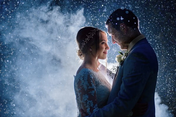 Bride and groom surrounded by smoke and drops of water - Picture by Fiona Walsh Photography