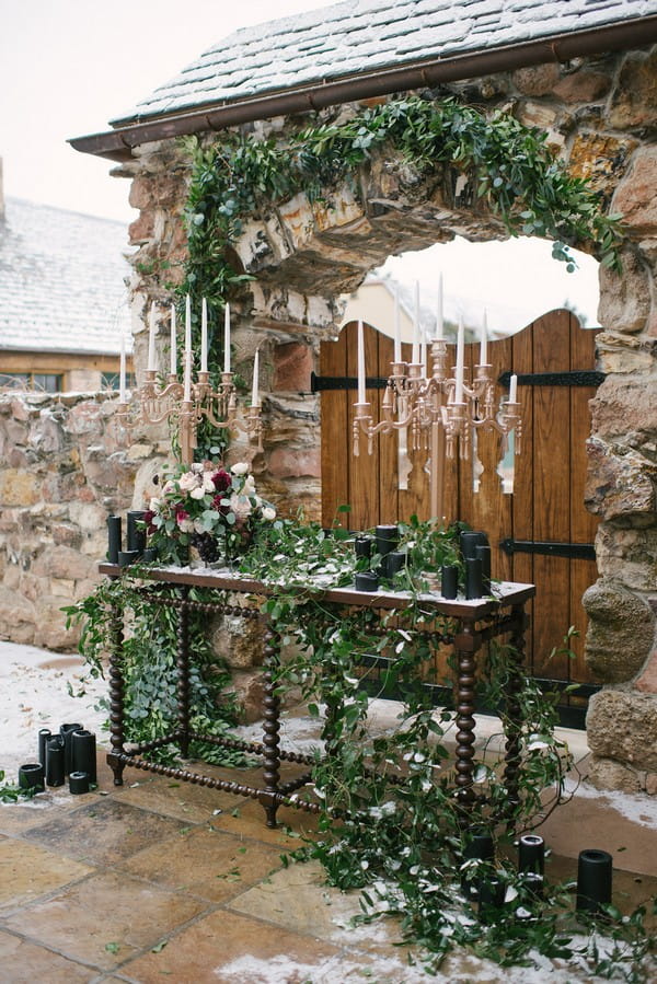 Wedding ceremony table with foliage and candelabra