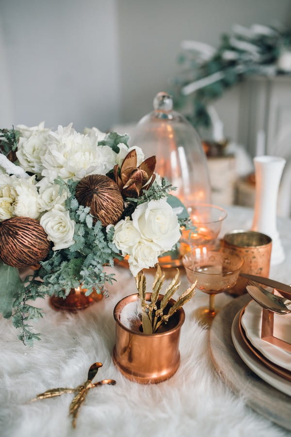 Copper cups and white flowers on wedding table