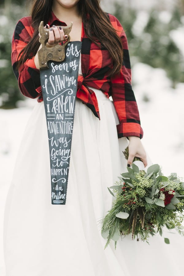 Bride holding saw with message written on it