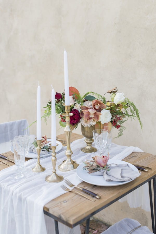 High candles and winter flower arrangement on wedding table