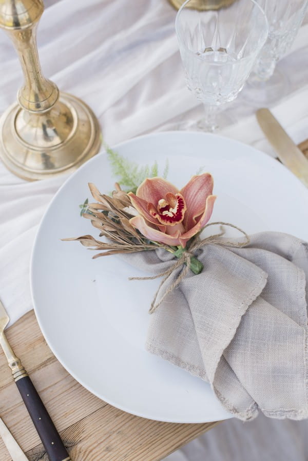 Flower and napkin on plate at wedding place setting