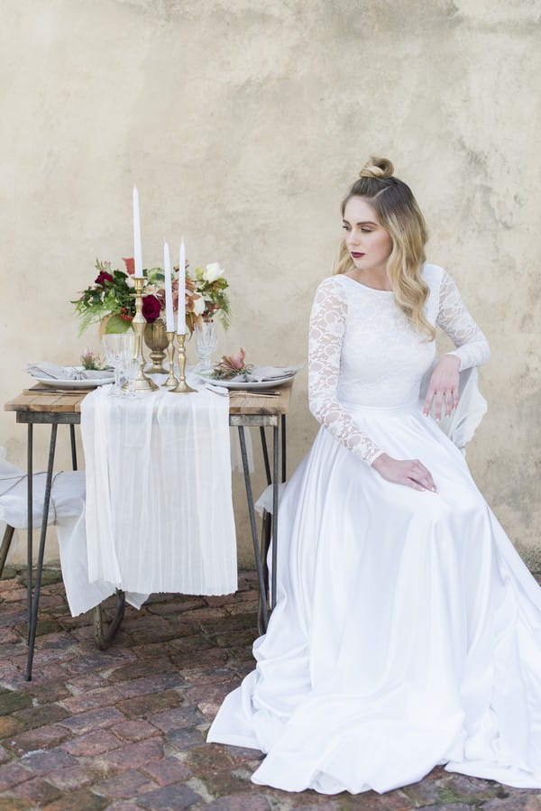 Bride sitting at small wedding table