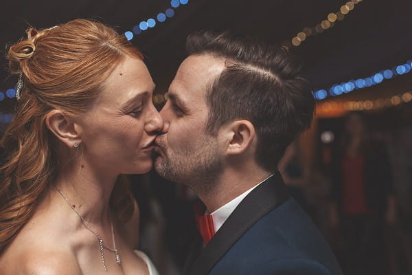 Bride and groom kiss on dance floor