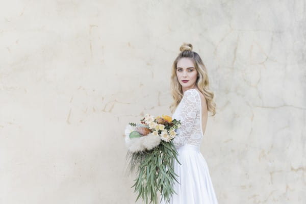 Bride holding bouquet with trailing foliage