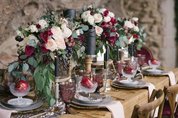 Long wedding table with red and white floral centrepiece