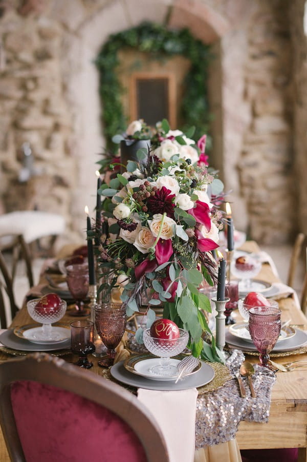 Red and white flowers with foliage down centre of wedding table