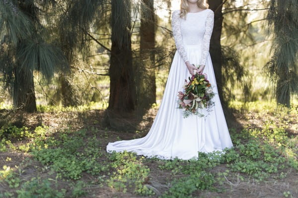 Bride holding large trailing bouquet in front of her