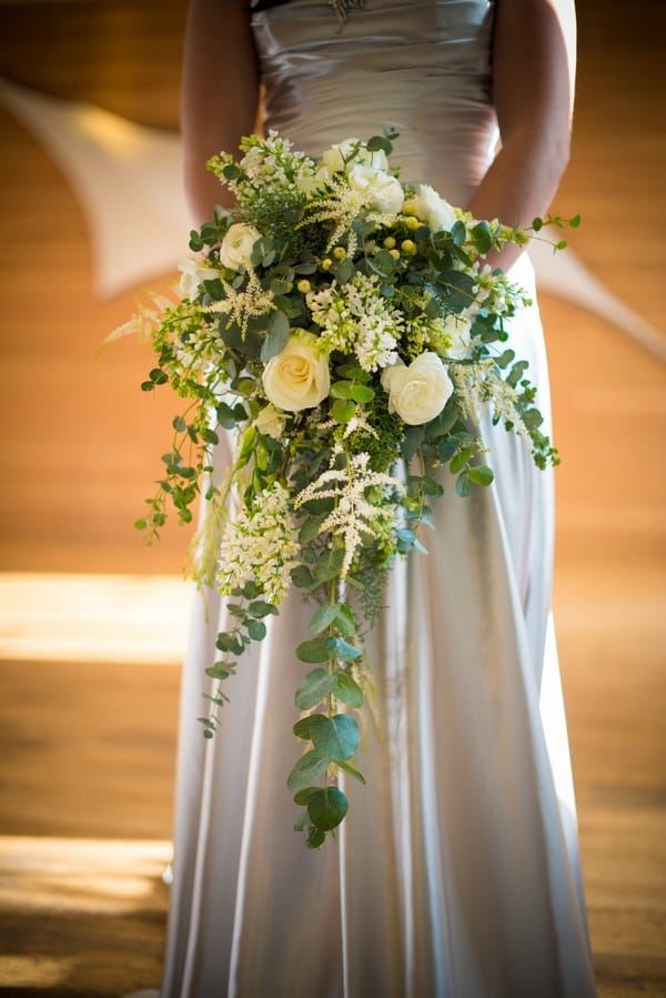 Bride Holding Cascading Bouquet with Roses and Foliage