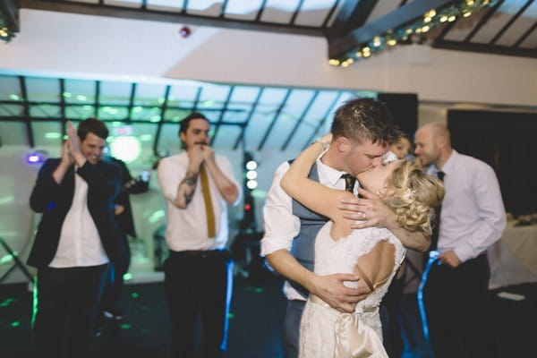 Bride and groom kissing on dance floor