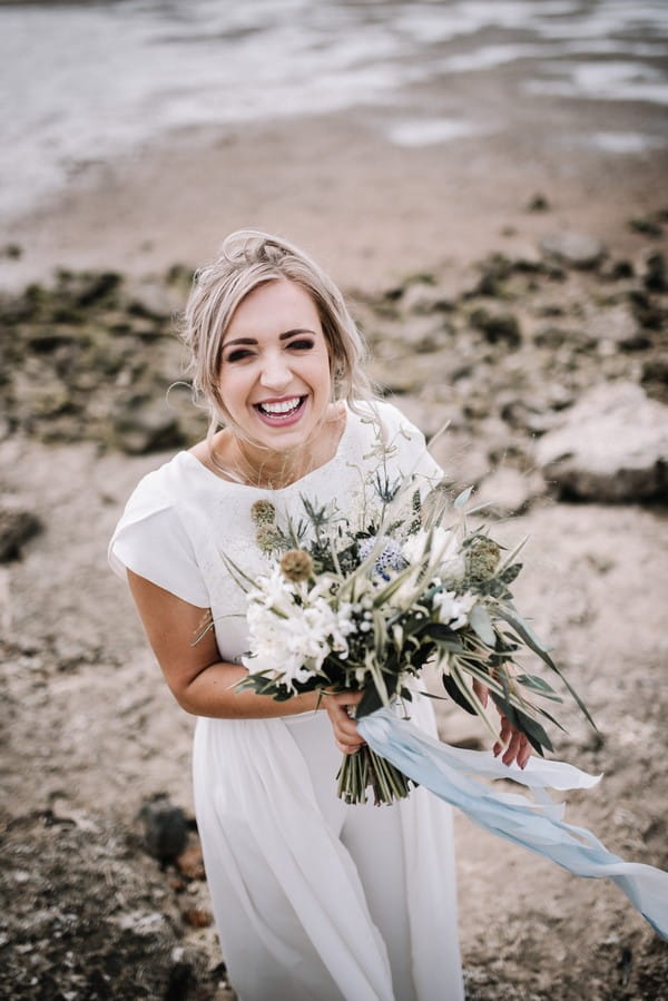 Bride smiling and holding bouquet