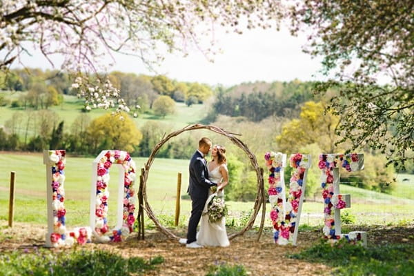 Bride and groom in middle of flower LOVE letters