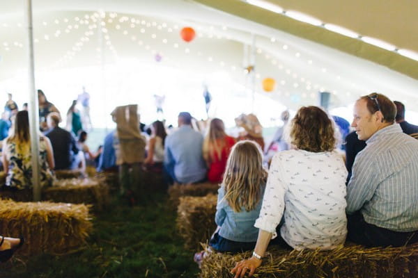 Wedding guests sitting on straw bales for wedding ceremony