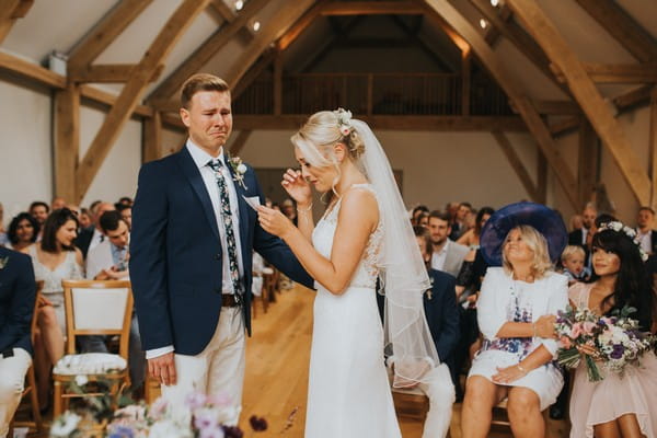 Bride and groom getting emotional as bride reads vows during wedding ceremony - Picture by Suzi Photography