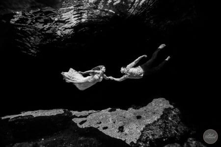 Bride and groom holding hands underwater - Picture by That Moment Photo