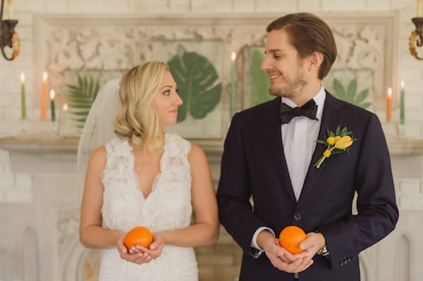 Bride and groom holding oranges