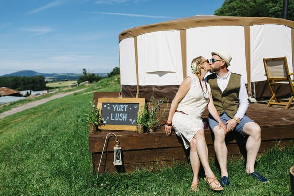 Bride and groom kissing in front of yurt