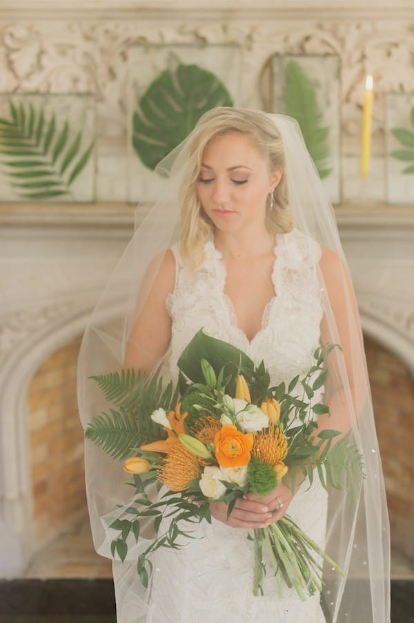 Bride holding bouquet under veil