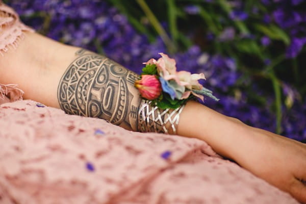Tattoo and wrist corsage on bride's arm