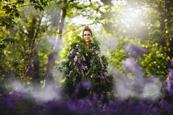 Bride in woodland covered in purple flowers and foliage