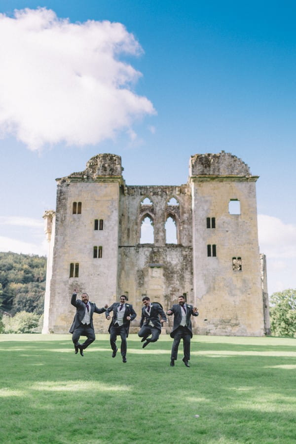 Groomsmen jumping in front of ruin