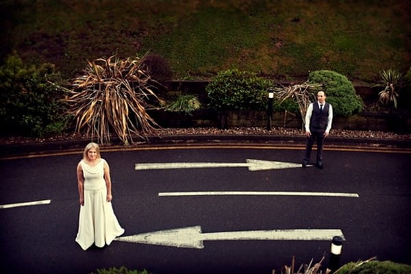 Bride and Groom in Road Next to Arrows