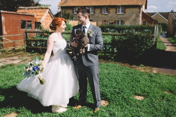 Bride with groom holding chicken