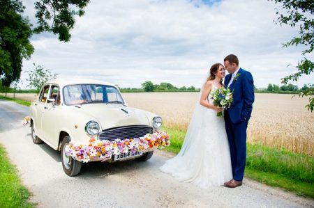 Bride and groom by Indian Ambassador car