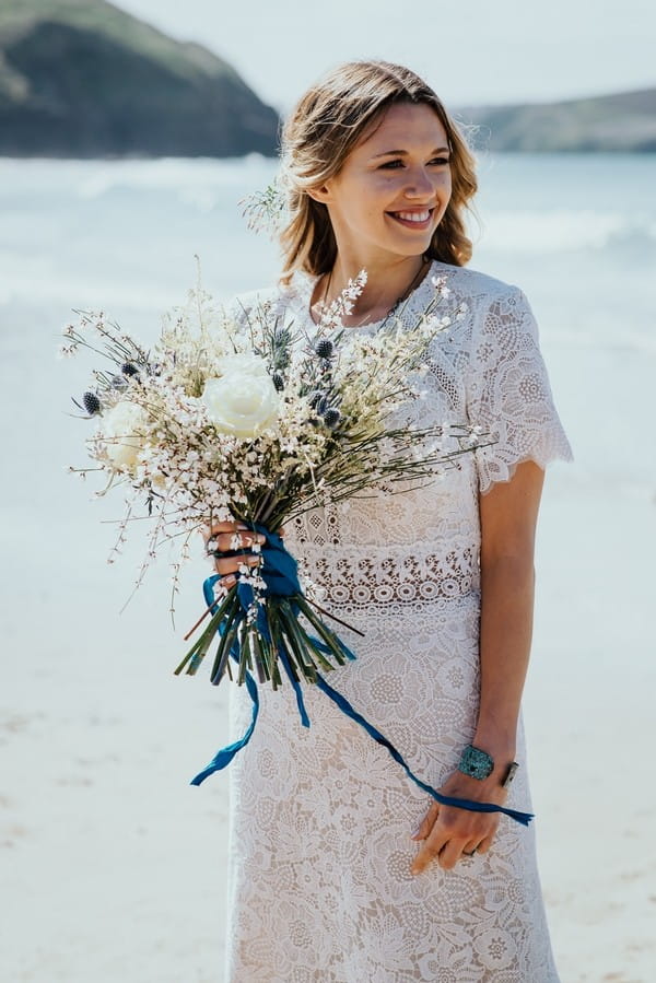 Bride holding large rustic bouquet with blue ribbon