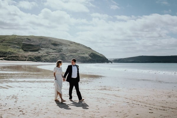 Bride and groom walking on beach