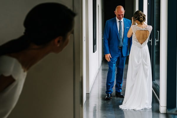 Lady peeking round corner at bride and groom - Picture by Kristian Leven Photography