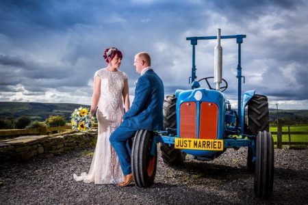 Bride and groom next to tractor with Just Married number plate - Picture by SJPhotographers