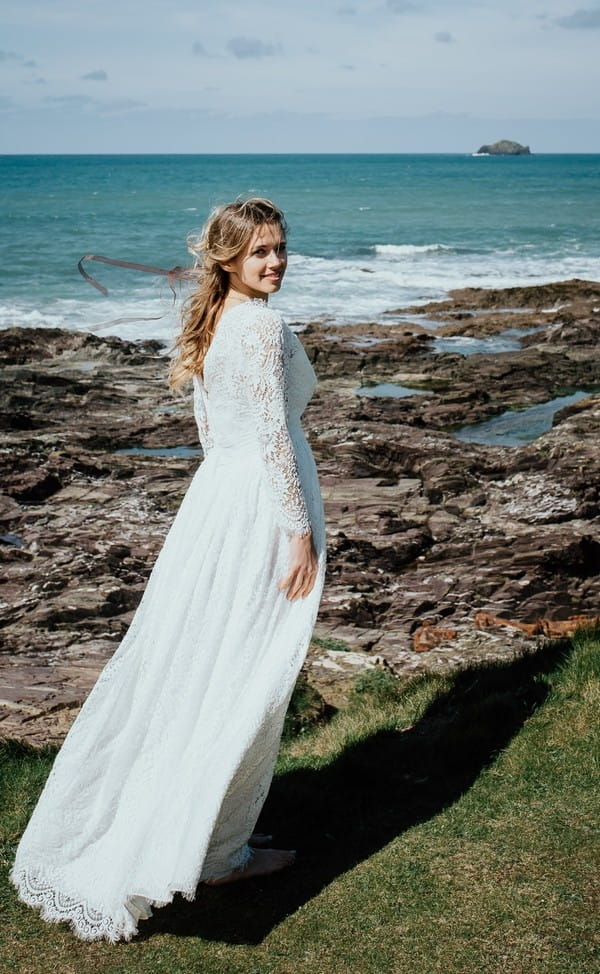 Bride by rocks on beach