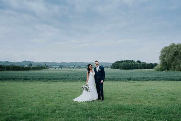 Bride and groom standing in field