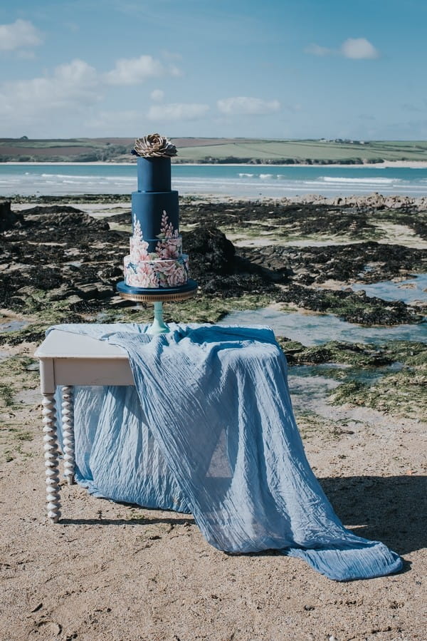 Blue wedding cake on table on beach