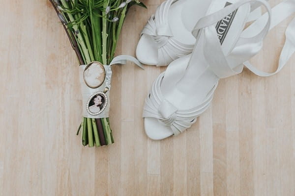 Bridal shoes and brooches on bouquet