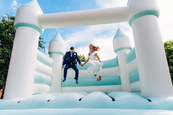 Bride and groom on bouncy castle - Picture by Damion Mower Photography