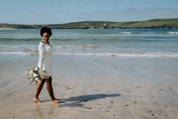 Bride walking across beach